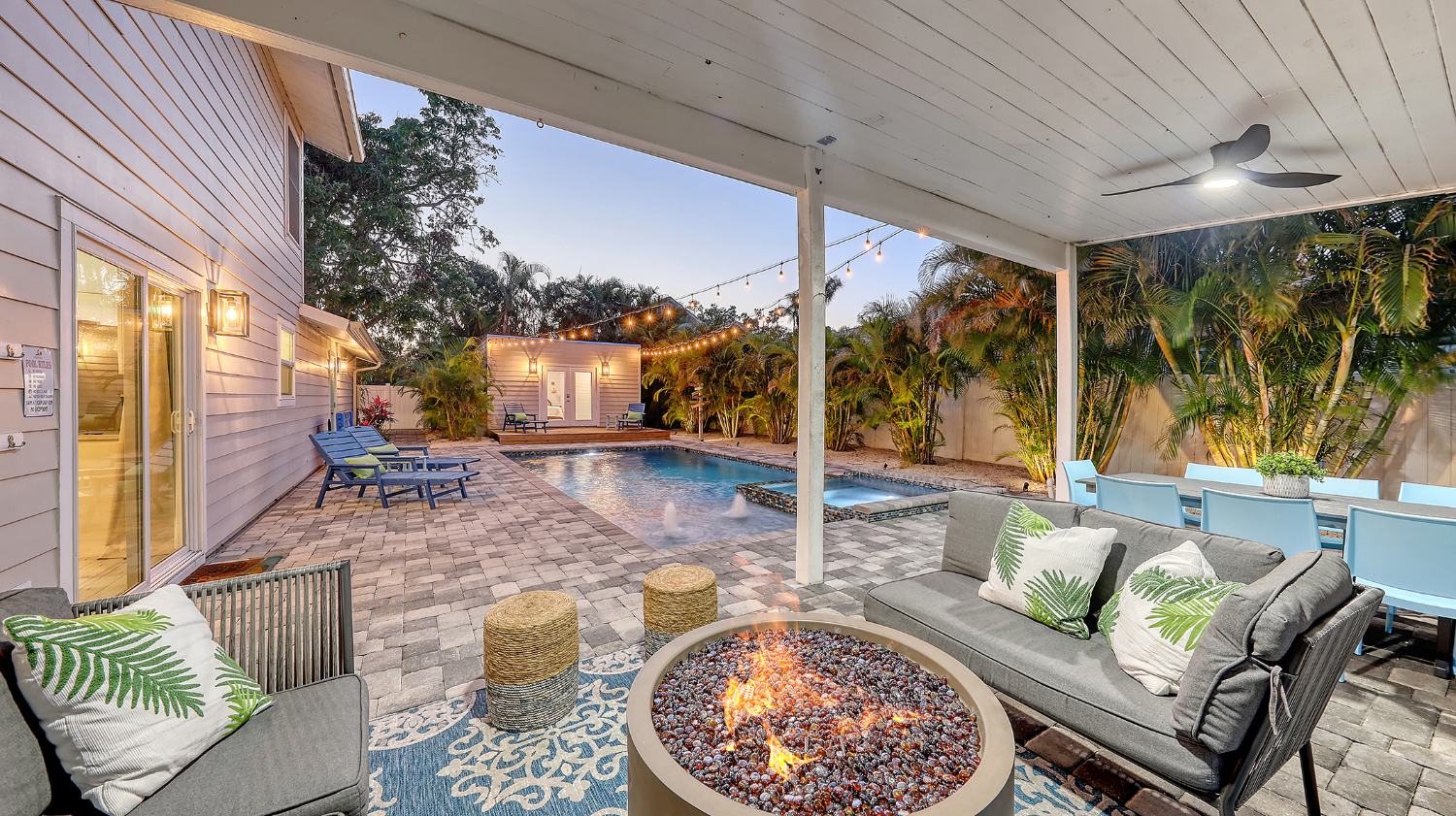 Fire pit and lounge by the pool at dusk
